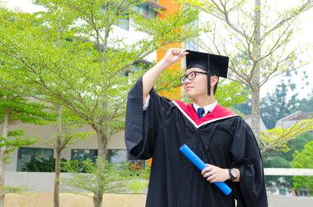 Asian university student in graduation gown and mortarboardの写真素材