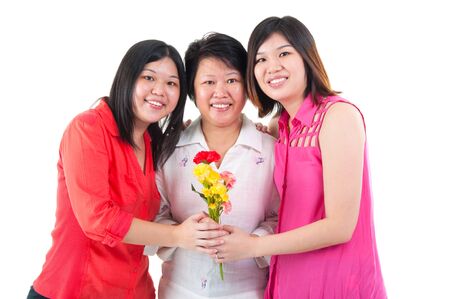 Asian woman receiving carnation flower from daughters on mothers day