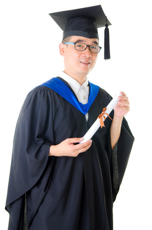 Asian man in graduation gown and holding certificateの写真素材