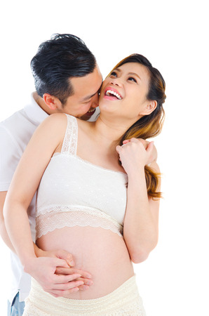 Indoor portrait of beautiful asian pregnant woman and her husbandの写真素材