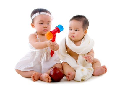 asian babies sitting on the floor playing toysの写真素材