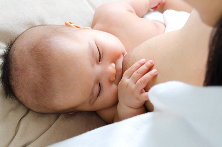 Three months old asian baby drinking breastmilkの写真素材
