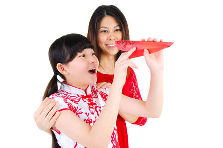Asian girl looking into the red packet with surprise expression. Chinese new year concept.の写真素材