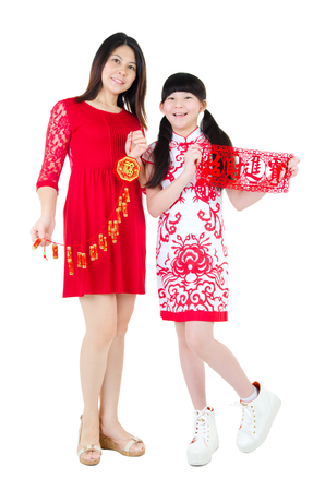 Asian woman holding firecracker decoration and asian kid holding paper cut with words symbolising "wealth in chinese character. Chinese new year concept.の写真素材