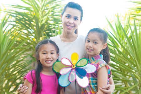 Outdoor portrait of cheerful asian mother and daughtersの写真素材