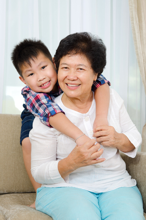 Indoor portrait of cheerful asian senior woman and grandsonの写真素材