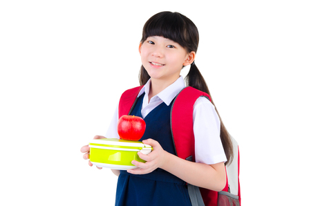 Asian primary school girl holding lunch box. Healthy eating concept for schoolchild.の写真素材