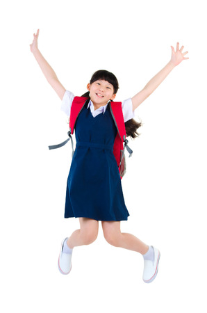 Excited asian primary school girl jump up isolated on white backgroundの写真素材
