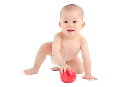 Indoor portrait of a lovely asian baby boy holding appleの写真素材