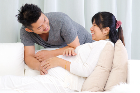 Asian man talking to his pregnant wifeの写真素材