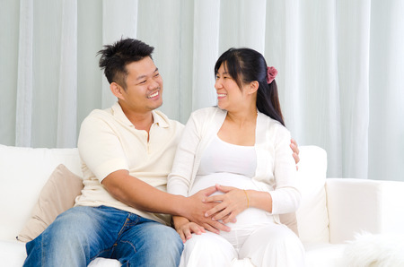 Asian man put his hand on his pregnant wife's stomachの写真素材