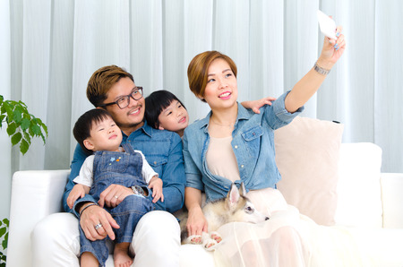 Asian family taking selfie at homeの写真素材