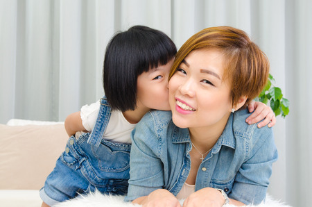 Portrait of lovely asian girl kiss her motherの写真素材