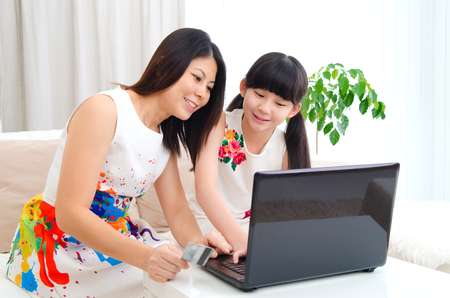 Beautiful asian woman and daughter performed online shopping with credit cardの写真素材