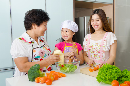 Asian three generations family enjoyed cooking in the kitchenの写真素材