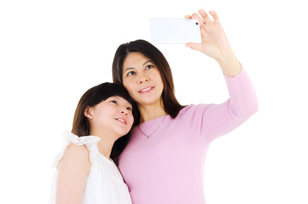 Asian mother and daughter taking photo with smartphoneの写真素材