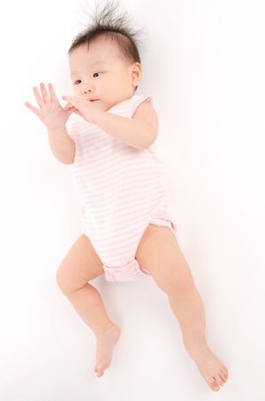 Asian baby looking at her fingersの写真素材