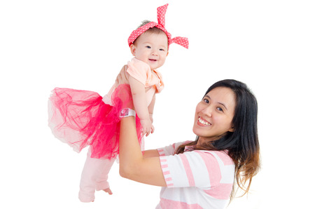 Asian mother lifting up her baby girlの写真素材
