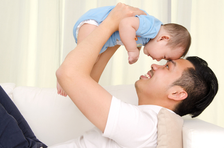 Indoor portrait of asian father and babyの写真素材