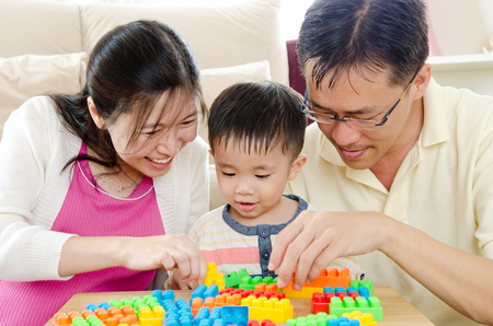 Asian parent playing building blocks with their son at homeの写真素材