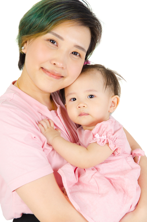 Indoor portrait of asian mother and her baby isolated on white backgroundの写真素材