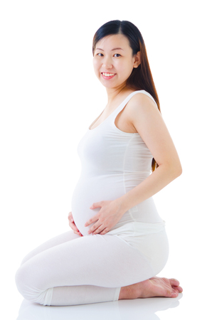 Indoor portrait of beautifull asian pregnant womanの写真素材