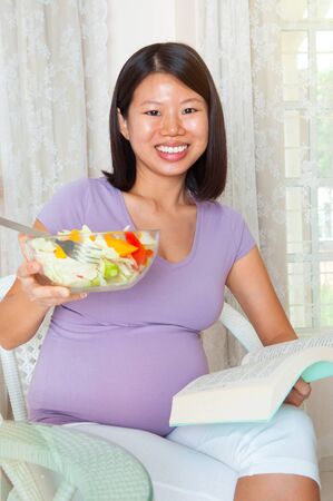Asian pregnant woman taking saladの写真素材