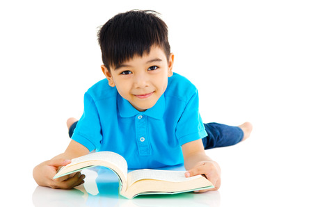 Asian boy lying on the floor and readingの写真素材