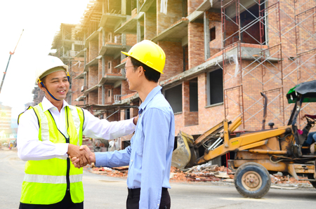 Asian engineers shake hands at the construction siteの写真素材
