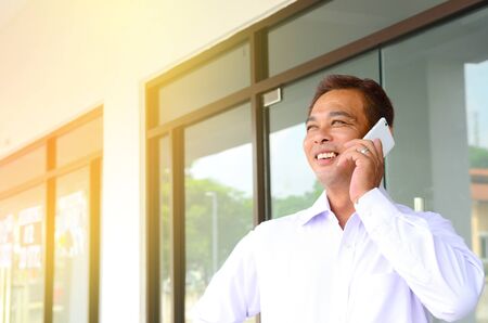 Asian middle aged businessman talking on the smartphoneの写真素材