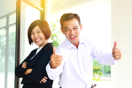 Cheerful middle aged asian businessman and businesswomanの写真素材