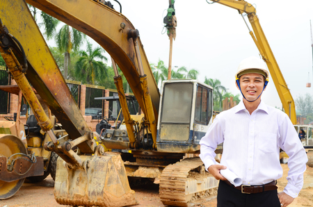 Asian engineer posing in front of a craneの写真素材
