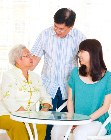Asian senior woman having conversation with son and daughterの写真素材