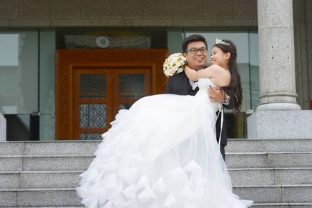 Asian groom lift up his brideの写真素材