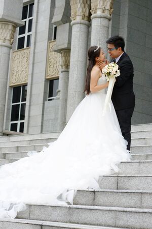 Asian groom touch his bride's faceの写真素材