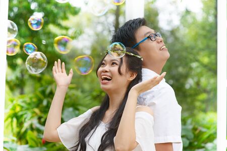 Asian young couple playing with bubblesの写真素材
