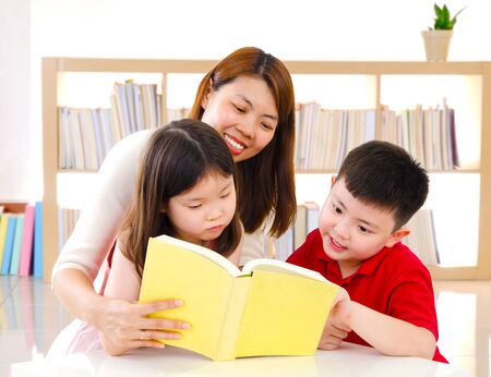 Asian mother and kids enjoyed reading at homeの写真素材