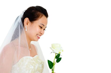 Asian bride looking at flowerの写真素材