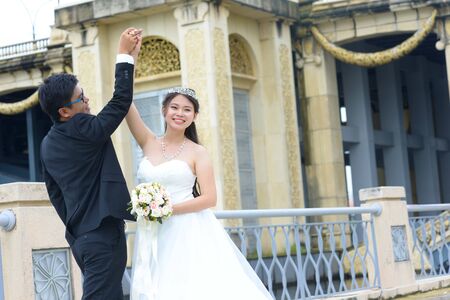 Asian bride and groom dance happilyの写真素材