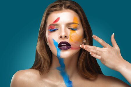 Painted beautiful woman face, artistic make up, body and face art, close up. Facial expression, emotions.の写真素材