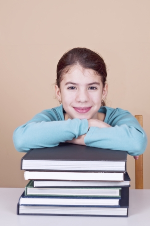 Young woman sitting by desk with booksの写真素材