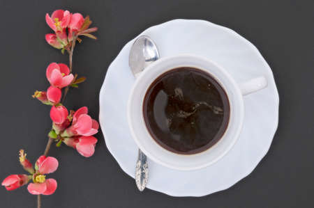 Coffee cup with coffee, hand and flower on blackの写真素材