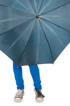 Young woman legs looking out from umbrella on isolated white background