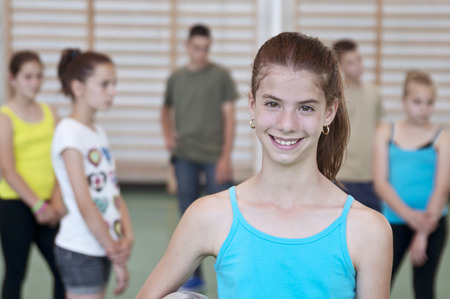Teens in gymnasium one woman looking into cameraの写真素材