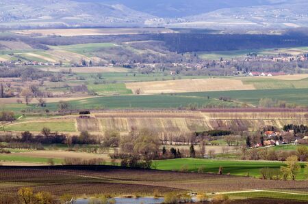 Sunny landscape with hills, roads, houses and agricultural areas from slightly above at spring timeの写真素材