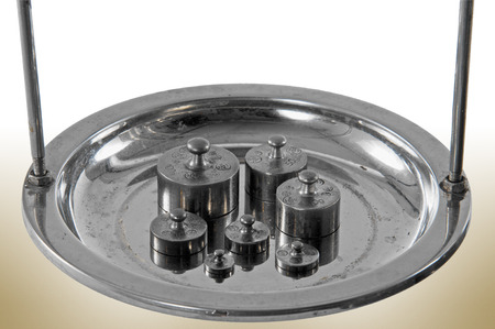 Traditional old style pharmacy scale pan close-up with small weights