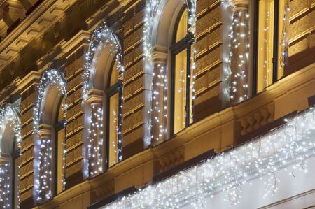 Building facade with light string decoration at night with lighting windowsの写真素材