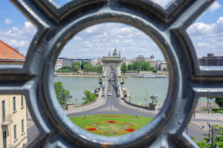 Budapest Chain bridge with river Danube view framed by fence detail at sunny dayの写真素材