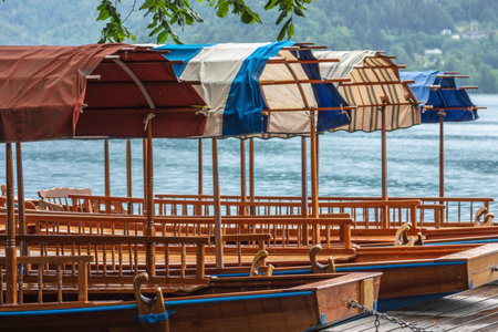 Small wooden gondola boats rest moored at Lake Bled, Sloveniaの写真素材
