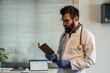 Close up portrait of handsome Caucasian senior joyful male doctor infectionist in white coat sitting in cabinet in clinic at work talking on video call online through webcam with patient medic conceptの写真素材